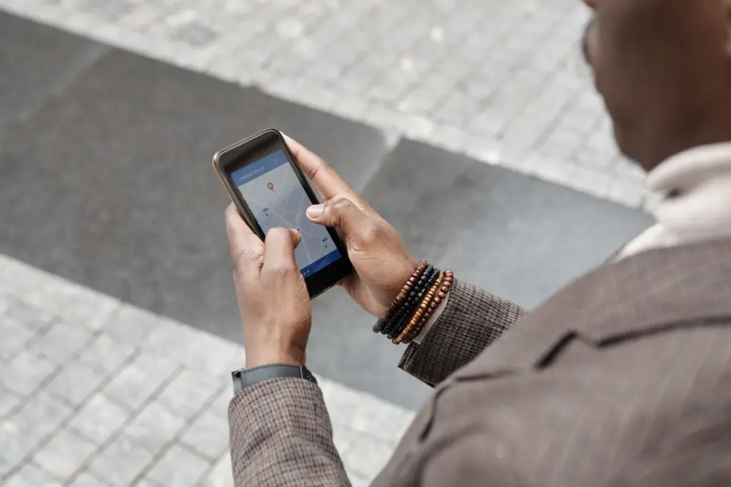Acasă (v2) Om pe stradă care caută pe telefon, pe hartă, o afacere din apropiere