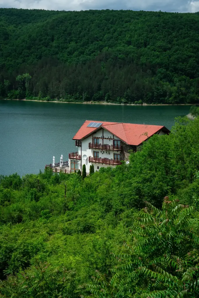Hotel cu balcoane și terasă pe malul unui lac de munte din România
